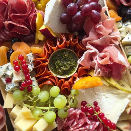 Generously filled sharing board with charcuterie, cheeses, fruit and dips