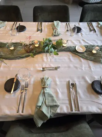 Table set with eucalyptus, laid out for a dinner at home